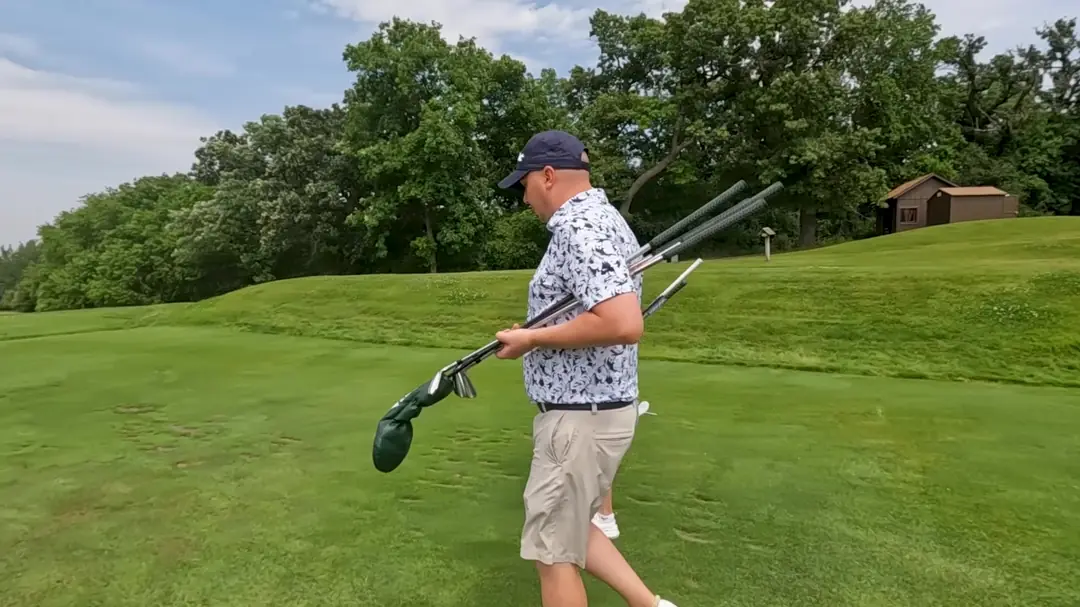 Two members walk up the fairway carrying their bags